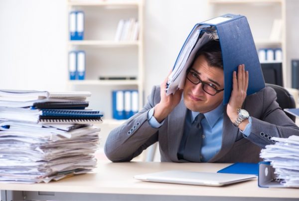 A man under pressure holding a binder over his head