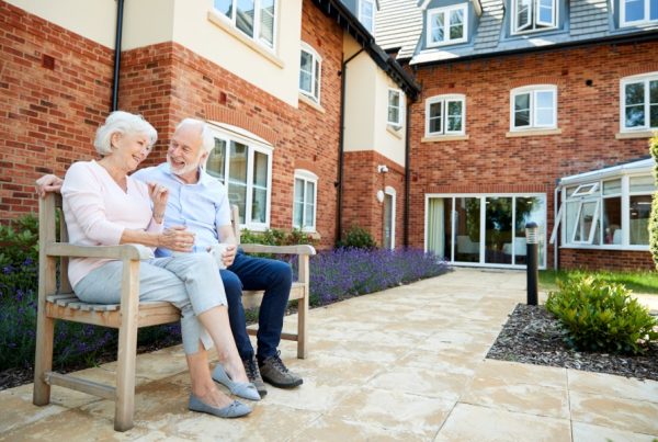 two elderly people on a bench outside of a building