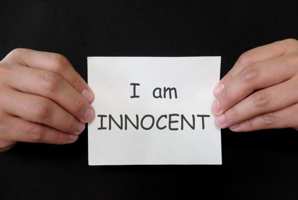 Hands holding a note that says I am innocent