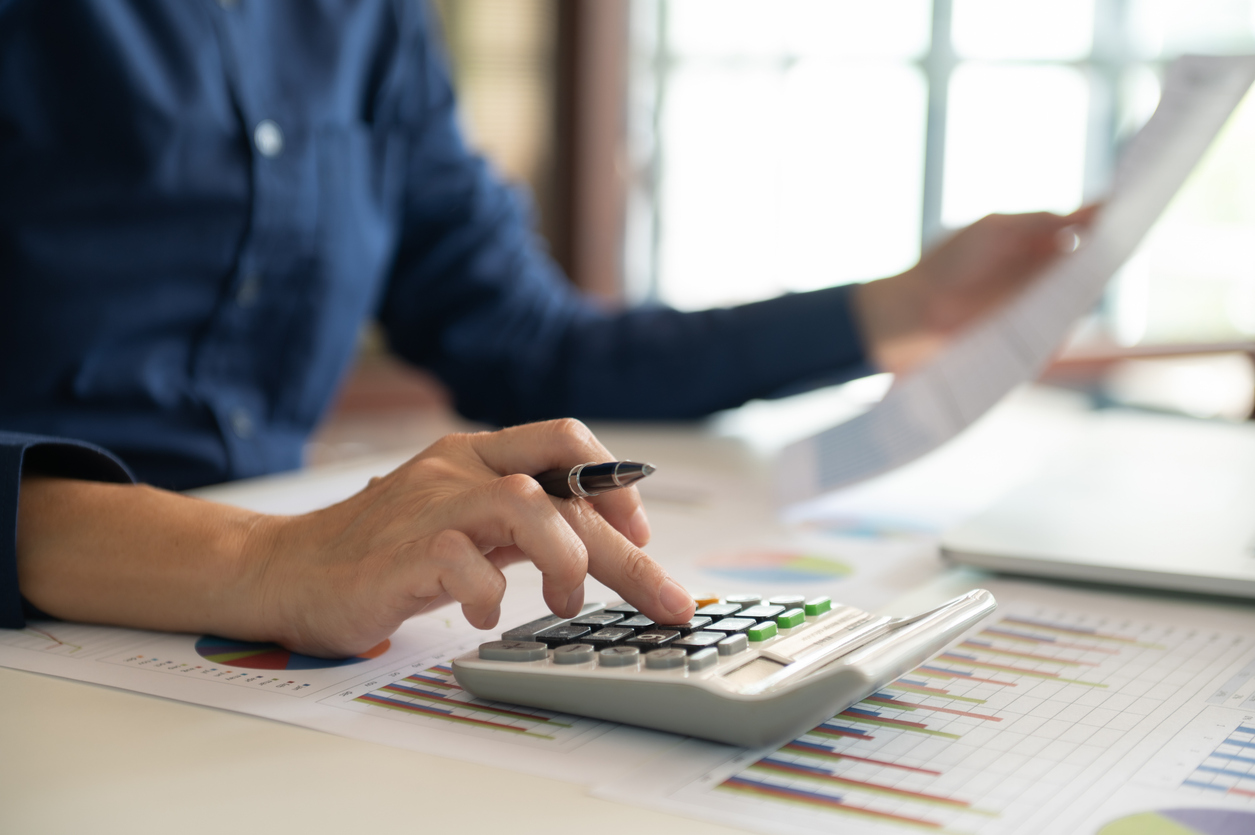 Tax calculation being prepared using financial records and a calculator